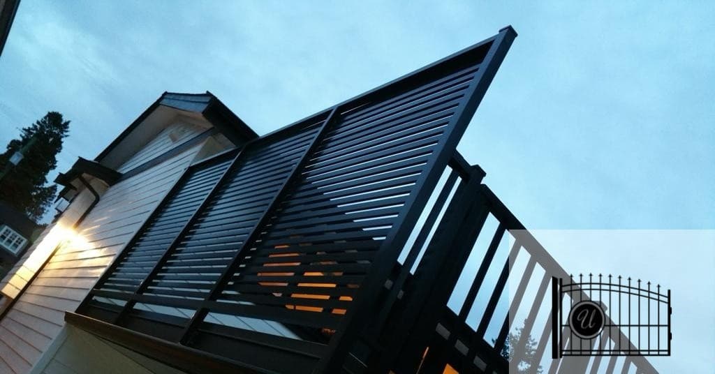 Black aluminum privacy panel and railing on a deck at dusk